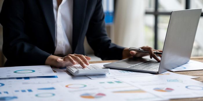 Accountants work analyzing financial reports on a laptop at his office, business analytics concept