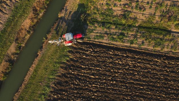 Aerial view with drone of tractor plowing the land in the countryside.