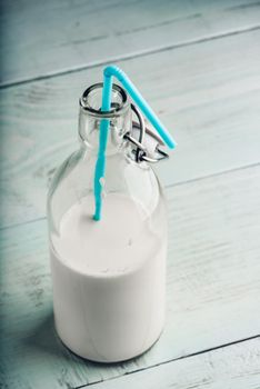 Almand milk in glass bottle with blue straw