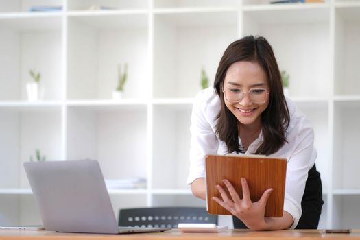 Happy young business woman entrepreneur using computer looking at screen working in internet sit at office desk, smiling hindu female professional employee typing email on laptop at workplace.