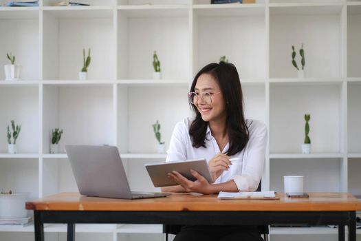 Beautiful woman Asian using digital tablet work at the office..