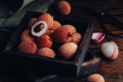 Small Box of Fresh Lychees on Wooden Table