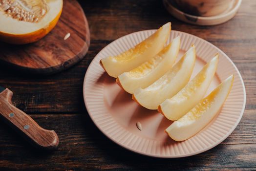 Sliced Sweet Yellow Melon on Plate over Wooden Surface