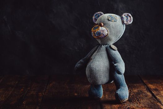 Close Up of Handmade Stuffed Bear Toy Standing on Wooden Surface