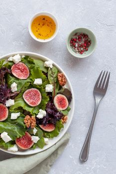 portion of fig, salad leaves, feta and walnuts salad, overhead