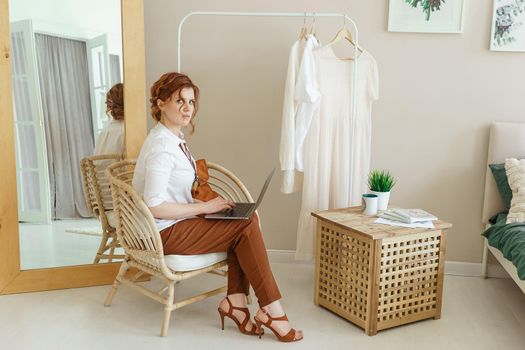 A business woman with a laptop. A human design specialist works at home on a laptop. Work from home during the epidemic.