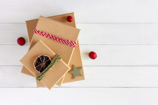 stack of Christmas gift boxes on the white wooden background, top view, zero waste concept