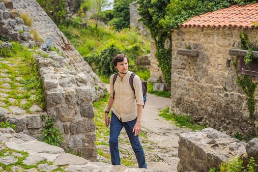 Man tourist walks through the old town of Bar in Montenegro. Happy tourist walks in the mountains. Suburbs of the city of Bar, Montenegro, Balkans. Beautiful nature and landscape.
