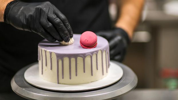 chef usign macaron , flowers and text sign for a celebration cake