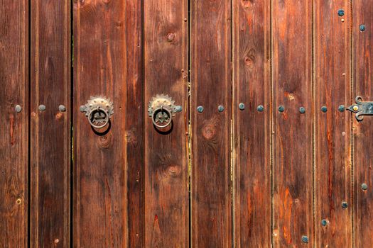 Old vintage wooden door ornate with a beauty metal furniture. Close up