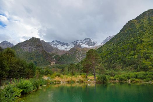Mountain landscape with a glacier in the distance. Lake in the mountains. Tana glacier in Ossetia