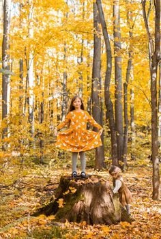 happy child girl throws autumn leaves and laughs outdoors
