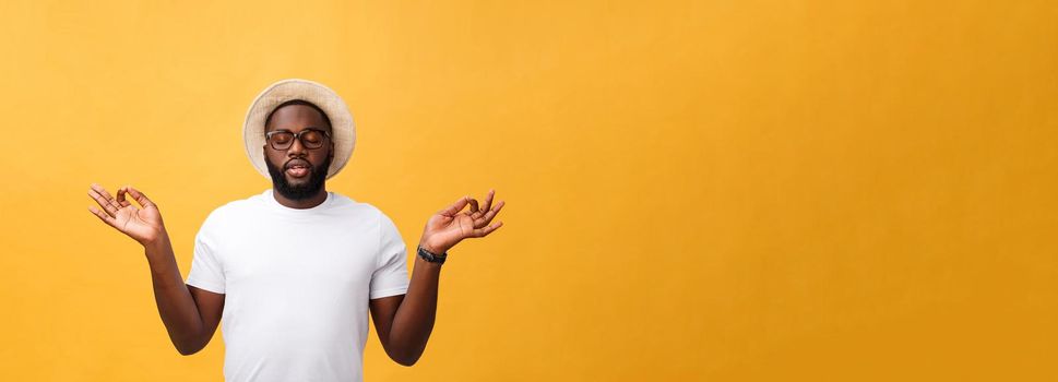 Closeup portrait of happy handsome, young man in meditation yoga mode, isolated on yellow background. Stress relief techniques concept