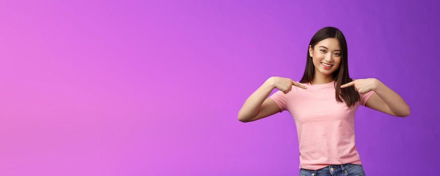 Active energized friendly tender asian stylish girl introduce herself, pointing chest proudly, smiling boastful, describe own achievements, bragging accomplishments, stand pleased purple background.