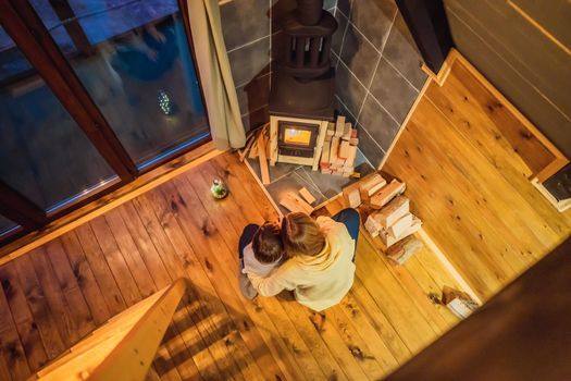 Mom and son spend time by the fireplace in Glamping. Rest in the mountains in Glamping. Cozy fireplace in a mountain house.