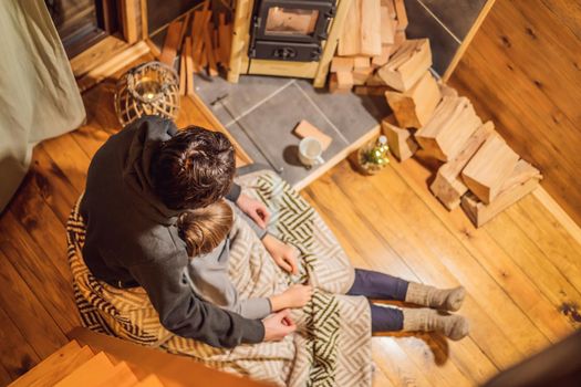 Dad and son spend time by the fireplace in Glamping. Rest in the mountains in Glamping. Cozy fireplace in a mountain house.