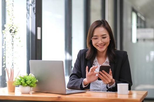 Young asian businesswoman beautiful charming smiling and talking on the mobile phone sitting at the office..