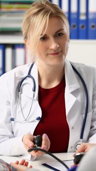 Doctor woman measuring blood pressure to patient in clinic. Medicine healthcare hypertension and cardiology