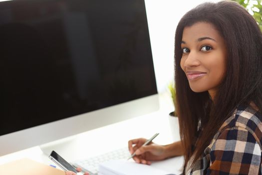 Black business woman holding phone making notes in modern office. Mobile apps fucking business concept