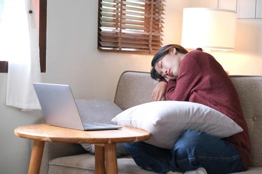 young asian woman sleeping break time or off line mode after using laptop relax sitting on couch or sofa, people lifestyle at home, digital detox concept.