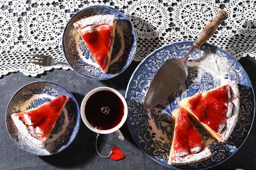 Valentines day, red strawberry pie on blue plates and a gift in a red box . High quality photo