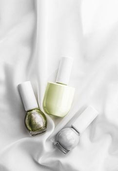 Cosmetic branding, salon and glamour concept - Nail polish bottles on silk background, french manicure products and nailpolish make-up cosmetics for luxury beauty brand and holiday flatlay art design