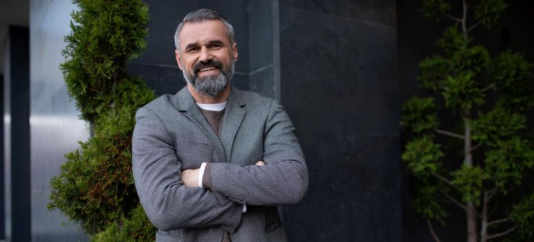 portrait of an adult successful grey-haired businessman with a smile on his face.