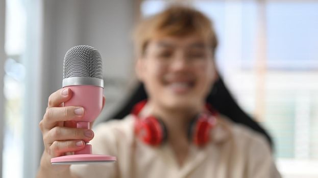 Image of radio host using microphone and laptop to recording podcast in home studio. Radio, podcasts and technology concept.