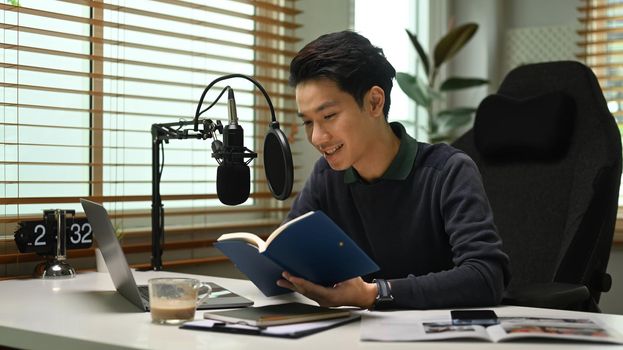 Image of radio host using microphone and laptop to recording podcast in home studio. Radio, podcasts and technology concept.