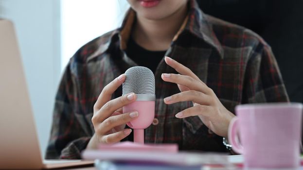 Image of radio host using microphone and laptop to recording podcast in home studio. Radio, podcasts and technology concept.