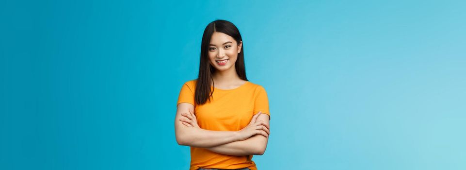Confident assertive good-looking asian girl with dark short hairstyle cross arms chest self-assured, ready help give advice friendly smiling camera, stand blue background upbeat motivated.