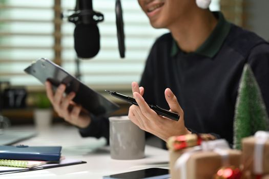 Image of radio host using microphone and laptop to recording podcast in home studio. Radio, podcasts and technology concept.