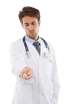 This is the recommend dose. Studio shot of a serious-looking young doctor holding a plie of pills up to the camera