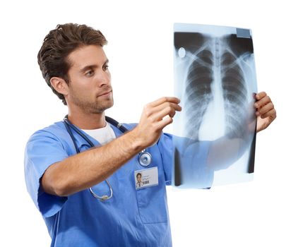 Focusing on finding a treatment. Studio shot of a handsome young doctor examining an x-ray he is holding up