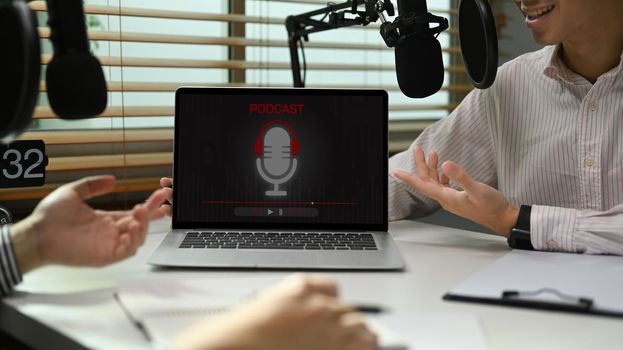 Image of radio host using microphone and laptop to recording podcast in home studio. Radio, podcasts and technology concept.