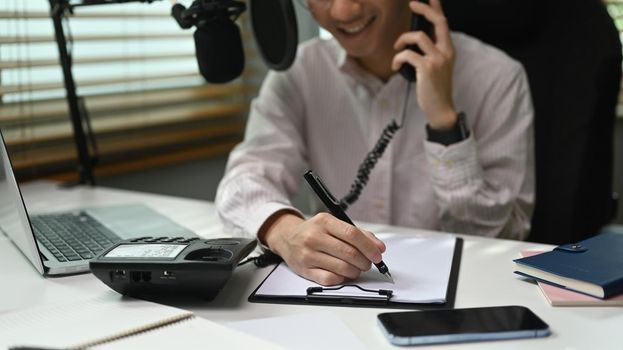 Image of radio host using microphone and laptop to recording podcast in home studio. Radio, podcasts and technology concept.