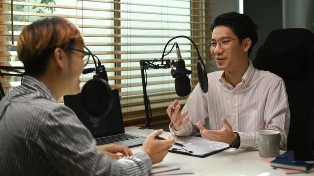 Image of radio host using microphone and laptop to recording podcast in home studio. Radio, podcasts and technology concept.