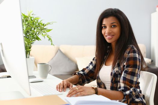 Positive afro business woman smiling at workplace at home. Remote work freelance and telework for students