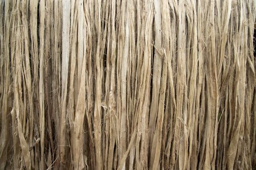 Closeup shot of raw jute fiber hanging under the sunlight for drying. Brown jute fiber texture and  background