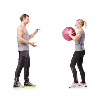 Fitness and friendship. A man and woman exercising by throwing a medicine ball to each other