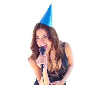 Shes the life of every party. An attractive young woman singing karaoke while wearing a party hat