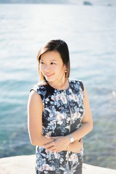 Woman in a colorful dress on a pier by the sea. Close-up. High quality photo