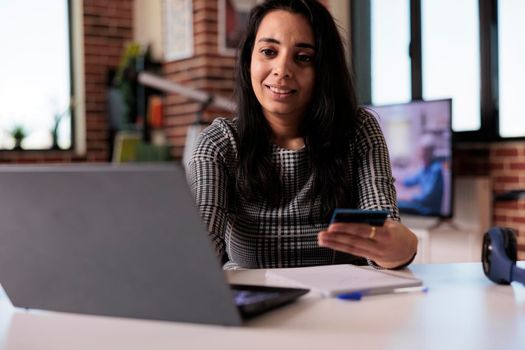 Indian person doing online shopping with credit card, making online purchase on retail store website. Doing electronic payment transaction on sale discount, remote work on laptop at home.