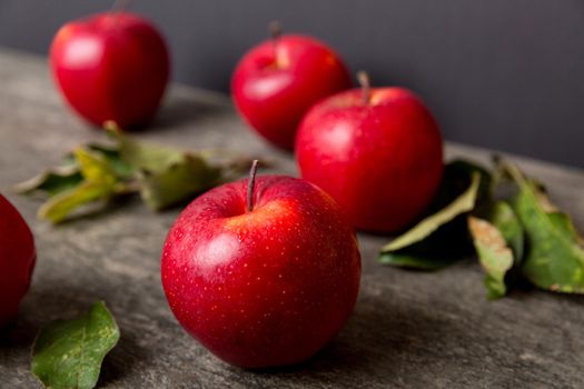 Fresh red apples with green leaves on wooden table. On wooden background. Top view free space for text.