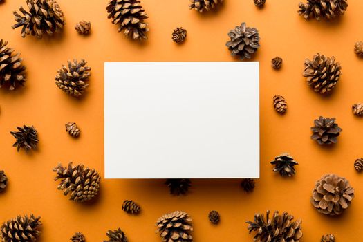 Creative frame made of Christmas pine cones with square Paper blank. Xmas and New Year theme. Flat lay, top view copy space.