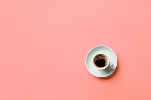 Blue cup of coffee on a colorful pink background. top view with copy space. morning concept.