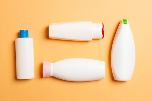 Set of White Cosmetic containers isolated on colored background, top view with copy space. Group of plastic bodycare bottle containers with empty space for you design.