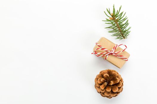 Christmas composition with pine cones fir tree branches and christmas gift box. Top view, flat lay on white background.