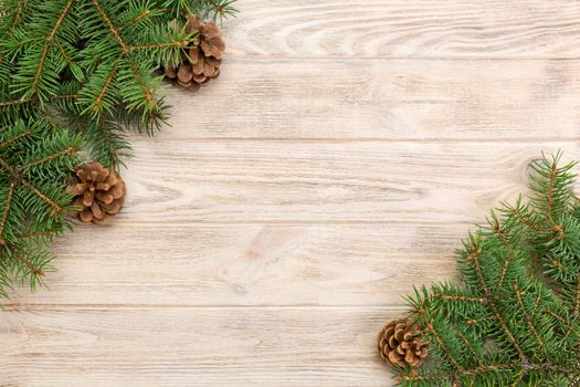 Christmas gray wooden background with fir tree frame and cones copy space. top view empty space for your design.