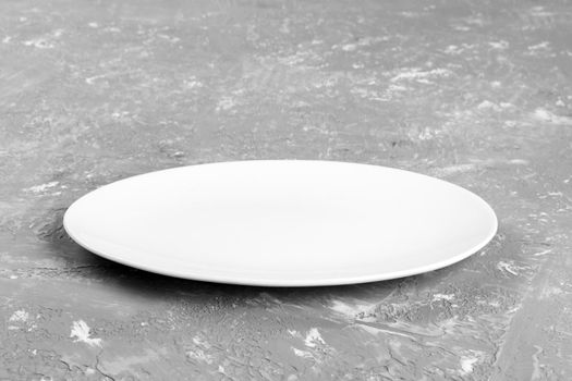 Empty plate on cement background. perspective view.